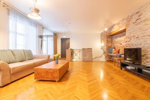 a living room with a couch and a tv at Old Town - Viru Gate Apartment in Tallinn
