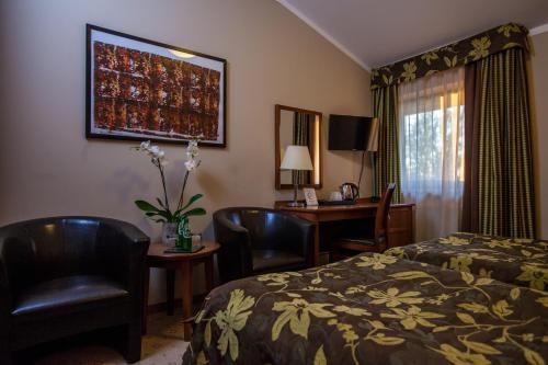 a hotel room with a bed and a desk at Farmona Hotel Business & SPA in Kraków