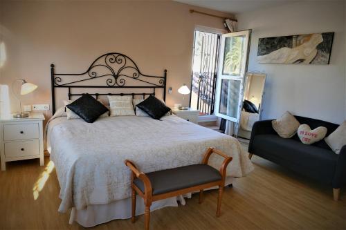 um quarto com uma cama, uma cadeira e um sofá em Casa de los Limones by Costadelsolholiday FAMILY VILLA NEAR PUERTO MARINA em Benalmádena