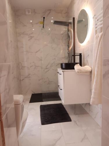 a white bathroom with a sink and a mirror at T2 tout confort, GP / Moto / 24h / Le Mans Classic in Le Mans