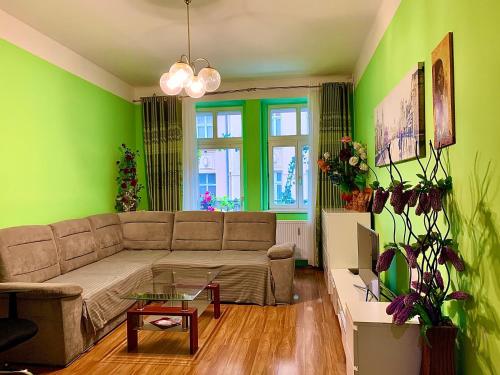 カルロヴィ・ヴァリにあるBlue Rose Apartmanの緑の壁のリビングルーム(ソファ付)