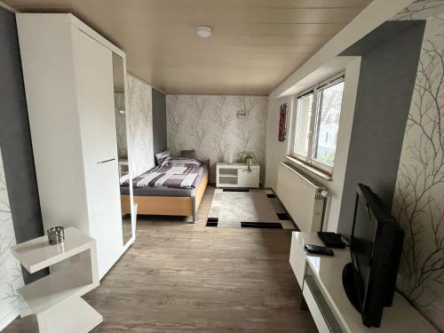 a bedroom with a bed and a television in it at Gästehaus Fährmann in Vehra