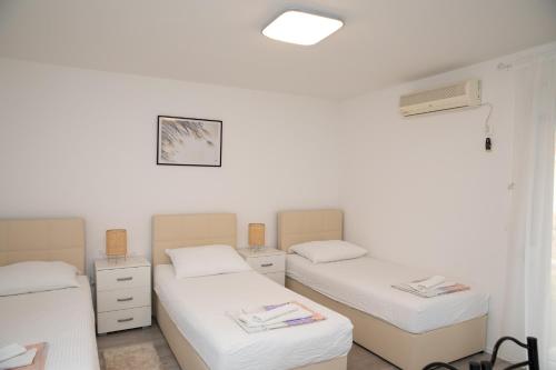 
a hotel room with two beds and a television at Apartment Kravica in Ljubuški
