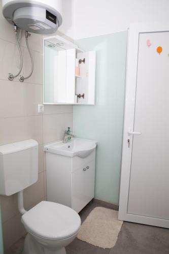 a bathroom with a toilet and a sink and a mirror at Apartment Kravica in Ljubuški