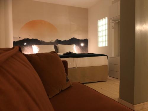 a bedroom with a bed and a couch and a window at Ankogel Lofts Mallnitz in Mallnitz