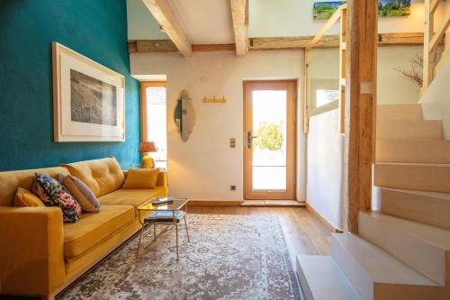 a living room with a couch and a staircase at GMOAHOUSE in Oggau