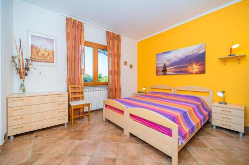 um quarto com uma cama e uma parede amarela em Appartamento villa da 4 fino a 5 persone giardino em Capoliveri