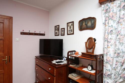 a living room with a television and a dresser with a dresserngth at Ostir Holiday Home in Cerknica