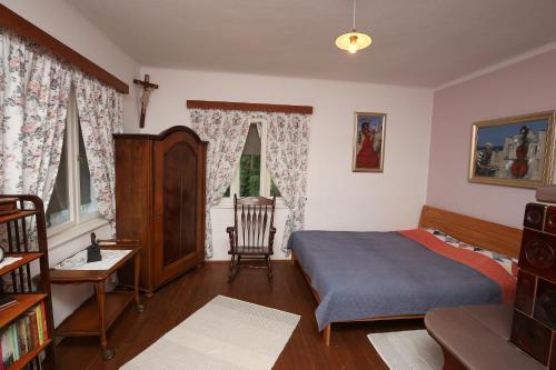 ein Schlafzimmer mit einem Bett und einem Stuhl darin in der Unterkunft Ostir Holiday Home in Cerknica