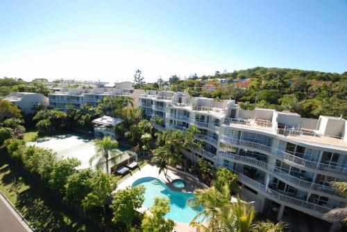 an aerial view of a resort with a pool and palm trees at Noosa Hill Resort in Noosa Heads