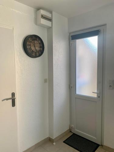 a clock on the wall next to a door at Gites des Lavandières in Cour-Cheverny