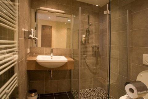 ein Bad mit einem Waschbecken und einer Dusche in der Unterkunft Hotel Kirchbichl in Hallwang