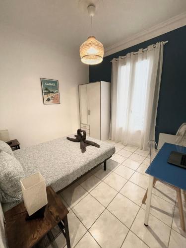 une chambre avec un lit, une table et une fenêtre dans l'établissement Joli appartement spacieux à 3 min à pied de la mer, à Nice
