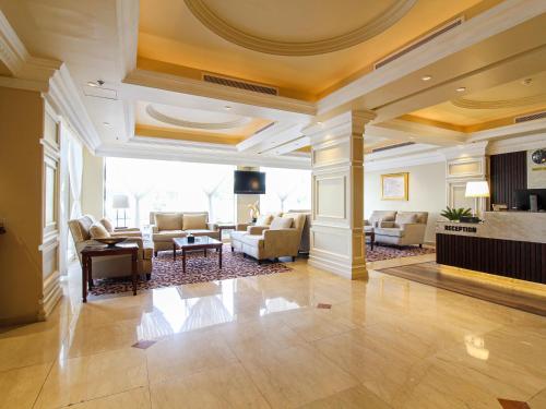 een grote lobby met een woonkamer met een open haard bij Lotaz Hotel - Al Shatea in Jeddah