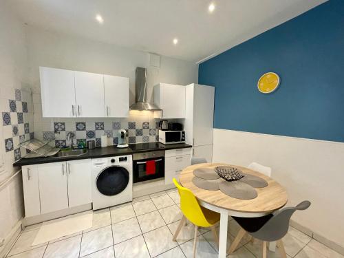 Il dispose d'une cuisine avec une table et d'une cuisine bleue. dans l'établissement Joli appartement spacieux à 3 min à pied de la mer, à Nice