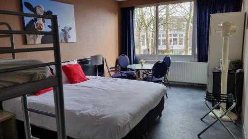 een slaapkamer met een stapelbed en een tafel en stoelen bij City Hotel Winschoten in Winschoten