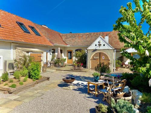 a house with a courtyard with a table and chairs at GMOAHOUSE in Oggau