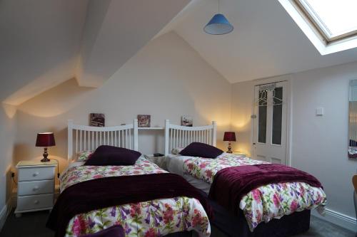 two beds in a room with white walls at Botanic View B&B in Dublin