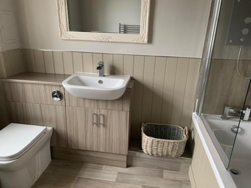 a bathroom with a sink and a toilet and a mirror at The Stair Arms Hotel in Edinburgh
