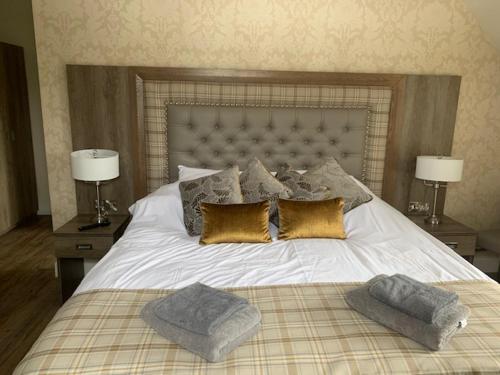 a bedroom with a large white bed with two lamps at The Stair Arms Hotel in Edinburgh