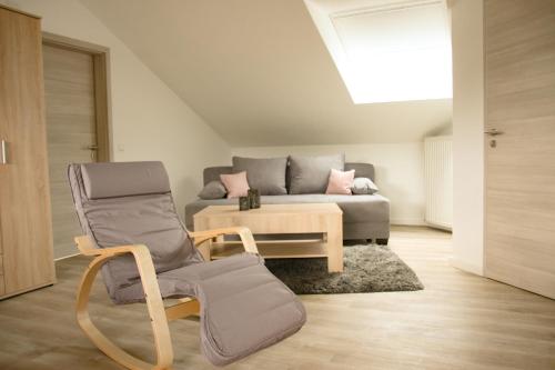 a living room with a couch and a chair at Gästehaus Mittendrin in Dahn