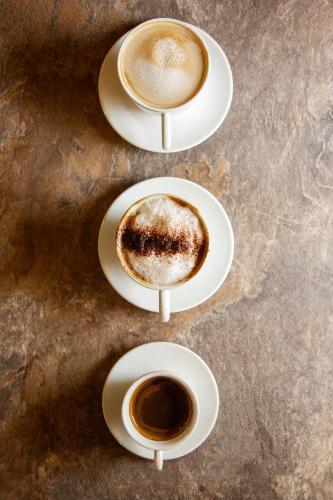 three cups of coffee on plates on a table at The Stair Arms Hotel in Edinburgh