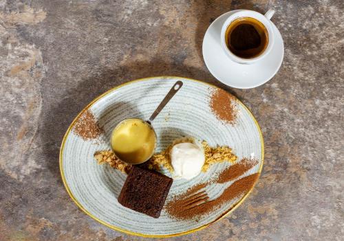 a plate with a dessert and a cup of coffee at The Stair Arms Hotel in Edinburgh