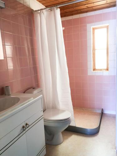 a pink bathroom with a toilet and a sink at Jacobs Stuga in Furudal