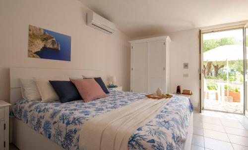 a bedroom with a bed with a blue and white comforter at Casa Palinuro Vacanze in Palinuro