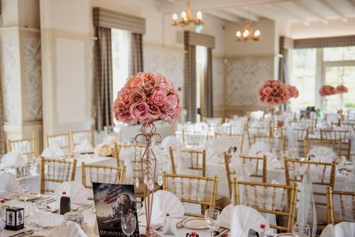 a room filled with tables and chairs with pink flowers at The Stair Arms Hotel in Edinburgh