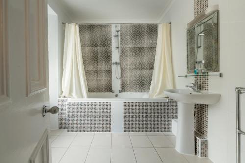 a white bathroom with a shower and a sink at Buchanan Arms Hotel & Leisure, Sure Hotel Collection in Drymen