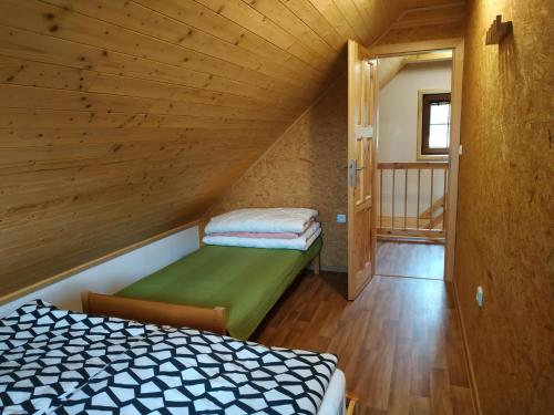 un dormitorio en el ático con una cama y una escalera en Chaty Nad Koupalištěm, en Borowa