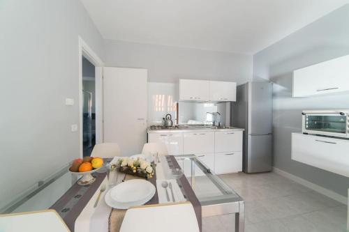 a kitchen with a glass table with a bowl of fruit on it at Luxurious attic-swimming pool in Riva di Solto