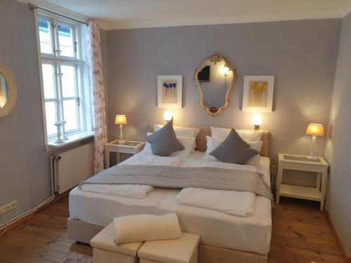 a bedroom with a large white bed with two windows at Hotel Bed & Breakfast am Dom in Schleswig