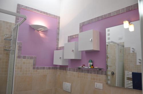 a bathroom with purple walls and a shower at Attico Romantico vista mare alla Maddalena in La Maddalena