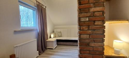 Cette petite chambre comprend un lit et une fenêtre. dans l'établissement Zacisze pod brzozami, à Kętrzyn