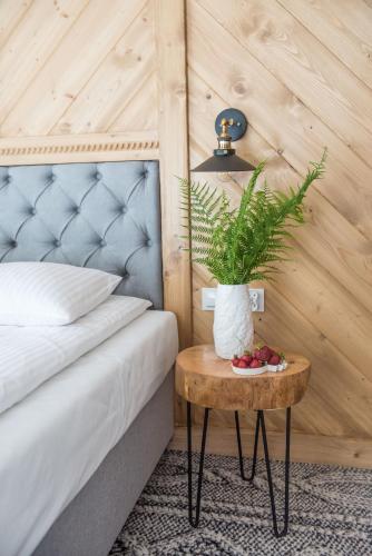 a bedroom with a bed and a table with a plant at Willa pod Orłem - Zakopane in Zakopane