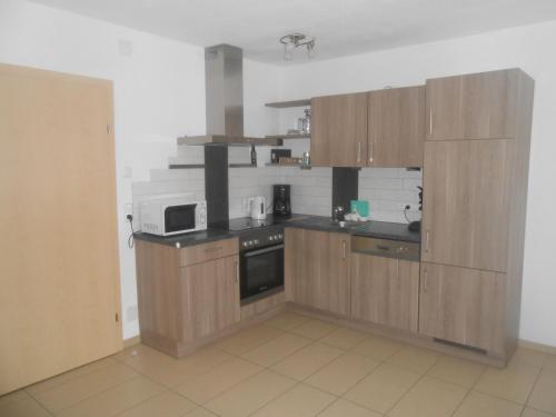 a kitchen with wooden cabinets and a microwave at Ferienwohnung Michaela in Flattach
