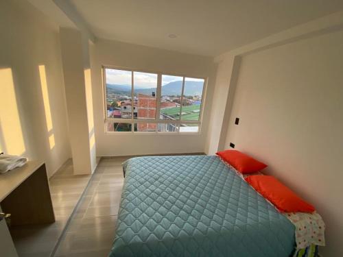 a bedroom with a bed and a large window at CASA TOÑITA in Oiba