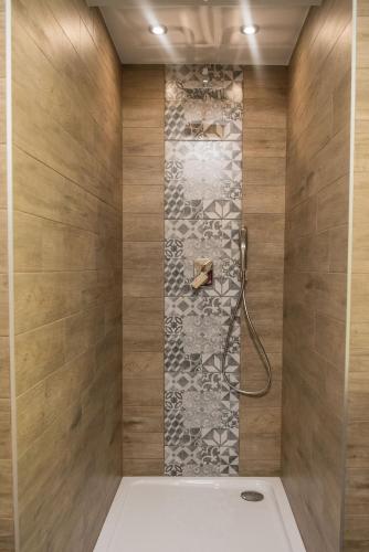 a bathroom with a shower with a stone wall at Willa pod Orłem - Zakopane in Zakopane