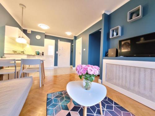 a living room with a vase of flowers on a table at My Beloved Warsaw City Center - NETFLIX in Warsaw
