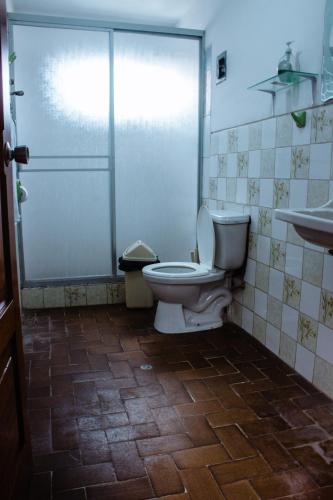 a bathroom with a toilet and a glass shower at Casa Libertad in Cusco