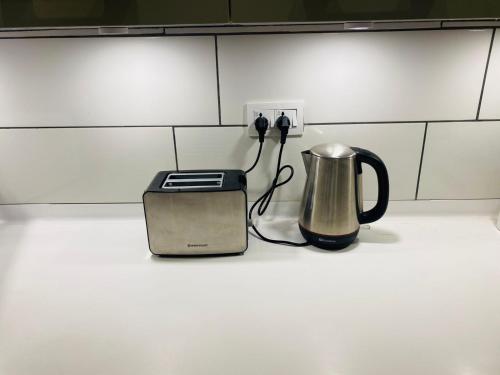 a toaster and a toaster sitting on a kitchen counter at Holidazzle Serviced Apartments Bahria Town in Rawalpindi