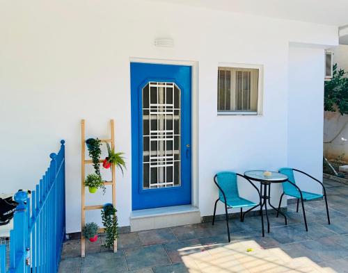 uma porta azul numa casa com uma mesa e cadeiras em Aristea’s place Askeli em Poros