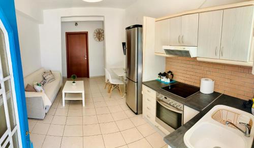 cocina y sala de estar con nevera y mesa en Aristea’s place Askeli, en Poros