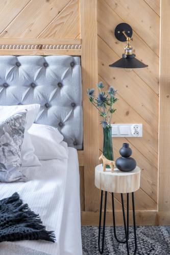 a bedroom with a bed with a vase of flowers on a table at Willa pod Orłem - Zakopane in Zakopane