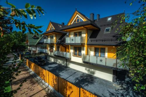 a house with a wooden fence in front of it at Willa pod Orłem - Zakopane in Zakopane