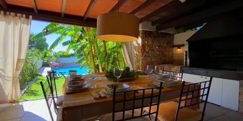 a dining room with a table and chairs and a large window at VILLA Bed and Breakfast - kitchen, Pool, Barbecue and Large garden in Benidorm