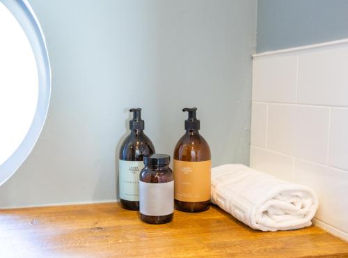 three bottles of wine sitting on a counter in a bathroom at The Crusoe in Leven