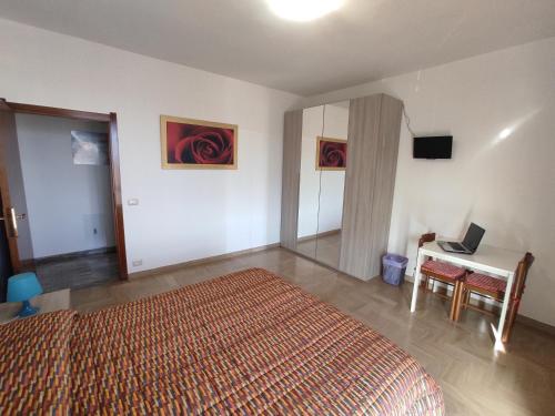 a bedroom with a bed and a desk with a laptop at B&B SunBeach in San Benedetto del Tronto